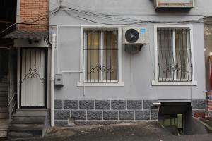 una casa blanca con tres ventanas y una puerta en Centre Apartment on Rustaveli av., en Tiflis