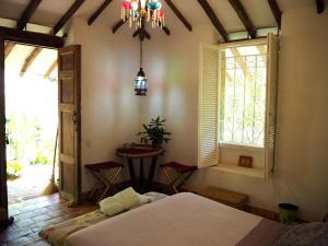 a bedroom with a bed and a window and a table at La Cabana de los Novios By Casas del Sur in Barichara