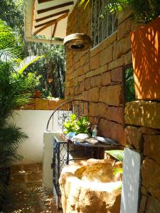 un patio con una mesa y una pared de piedra en La Cabana de los Novios By Casas del Sur, en Barichara