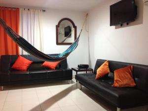 a living room with two black couches and a hammock at Apartamentos Cartagena in Cartagena de Indias