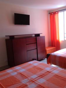 a bedroom with two beds and a television on the wall at Apartamentos Cartagena in Cartagena de Indias +34 photos