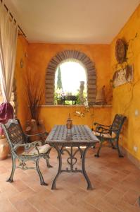 mesa y sillas en una habitación con ventana en La Culla Dei Castelli Romani, en Velletri