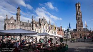 a group of people sitting at tables in front of a building at ibis budget Brugge Jabbeke in Jabbeke