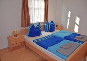 Schlafzimmer mit einem Bett mit blauer Bettwäsche und Kissen in der Unterkunft Ferienwohnungen Fiete & Ole in Ostseebad Sellin
