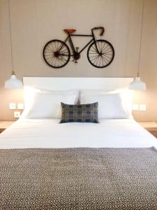uma bicicleta pendurada na parede acima de uma cama em Country House Villas Santarém em Santarém