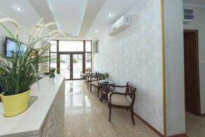 a dining room with tables and chairs and a plant at Hotel Promenada in Mamaia