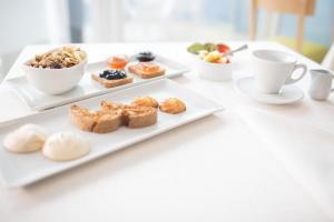 a table with two plates of pastries and cups of coffee at Hotel Mediterraneo in Sottomarina