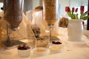 a table topped with containers of food and flowers at Hotel Mediterraneo in Sottomarina