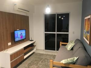 a living room with a couch and a television at Smart Residence Flat - 509 in Teresina