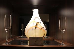 a vase on a table with two wine glasses at مؤسسة احمد محمد العرفج للوحدات السكنية - هوم ان - تصنيف اقتصادي in Al Khobar
