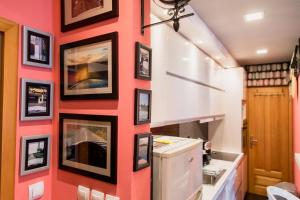 a red wall with pictures on it in a kitchen at Apartman u srcu grada in Sombor +86 photos