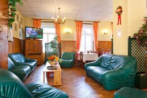 una sala de estar con sofás de cuero verde y una mesa. en Résidence SoAnSa du Gérardmer - Col de la Schlucht, en Soultzeren