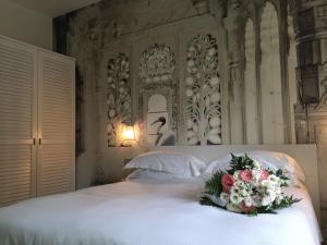 a bed with a bouquet of flowers on it at Arli Hotel Hideaway Punta Ala - Adults Only in Punta Ala