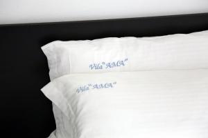 a white bed with two pillows with the words who rocked at Vila AMA Kruje in Krujë
