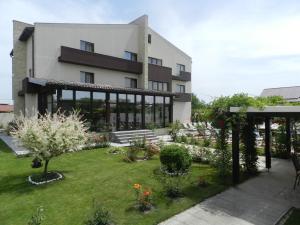 ein großes Gebäude mit einem Garten davor in der Unterkunft Pensiunea de Vis in Buftea