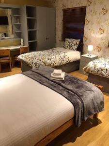 1 dormitorio con 2 camas y escritorio en Rockhill hospitality en Coleraine