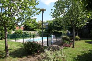 圖盧茲的住宿－Lespinet，树木繁茂的院子中围绕着游泳池的围栏