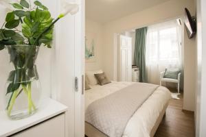 a bedroom with a bed with a vase of flowers at Apartmani Leo-Marin in Makarska