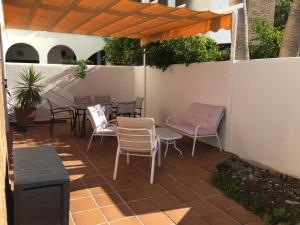 een patio met stoelen en tafels en een hek bij Playa Granada Golf in Motril