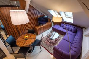 a living room with a purple couch and a table at Amiss Apartments in Košice