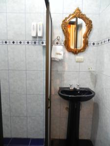 a bathroom with a sink and a mirror at Hotel Vieja Mansion in Cuenca