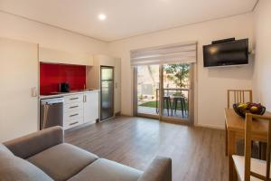 a living room with a couch and a kitchen at Latitude20 The Dunes in Karratha