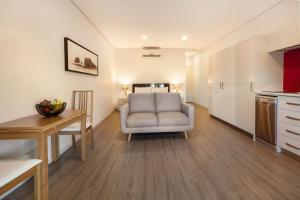 a living room with a chair and a table at Latitude20 The Dunes in Karratha