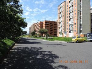 Un coche amarillo circulando por una calle con edificios altos. en LO MEJOR DE BOGOTAa, en Bogotá