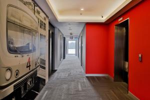 a corridor with red walls and a hallway with a train on the wall at Red Planet Manila Bay in Manila