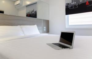 a laptop computer sitting on top of a bed at Red Planet Manila Bay in Manila