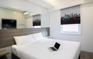 a bedroom with a bed with a laptop on it at Red Planet Manila Bay in Manila