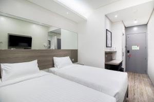 a hotel room with two beds and a mirror at Red Planet Manila Bay in Manila