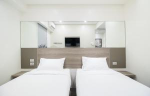 two beds in a room with a tv at Red Planet Manila Bay in Manila