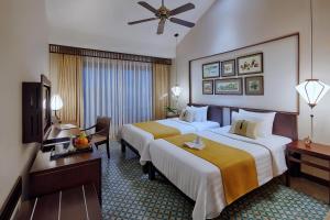 une chambre d'hôtel avec deux lits et une télévision dans l'établissement Little Hoi An . A Boutique Hotel & Spa, à Hội An