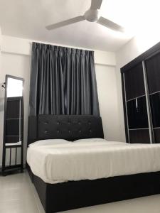 Muslim Homestay Apartment في جورج تاون: غرفة نوم مع سرير كبير مع اللوح الأمامي الأسود