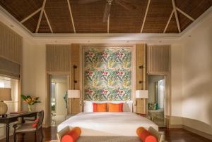 ein Schlafzimmer mit einem großen Bett mit Wandbild in der Unterkunft Anantara Mai Khao Phuket Villas in Mai Khao Beach + 37 Fotos