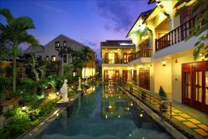 a hotel with a swimming pool at night at Truc Huy Villa in Hoi An