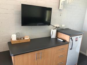a black counter top with a tv on a wall at Bateau Bay Hotel in Bateau Bay