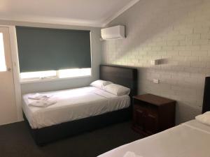 a hotel room with two beds and a window at Bateau Bay Hotel in Bateau Bay