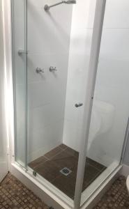 a shower with a glass door in a bathroom at Bateau Bay Hotel in Bateau Bay