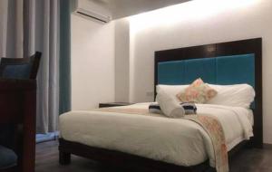 إل بويرتو بوراكاي في بوراكاي: غرفة نوم مع سرير كبير مع اللوح الأمامي الأزرق
