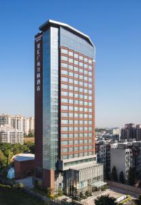 a tall building with glass windows in a city at Fairfield by Marriott Dongguan Changping in Dongguan