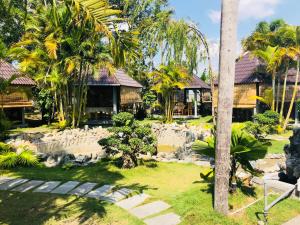 a resort with a yard with trees and buildings at Trieu Khang Hotel gần sân bay Cam Ranh near Cam Ranh Airport in Cam Ranh