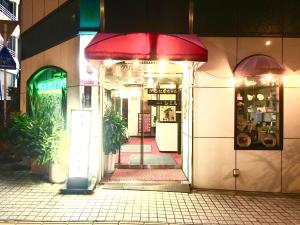 een toegang tot een winkel met een rode paraplu bij Green Hill Hotel Tennoji Ekimae in Osaka