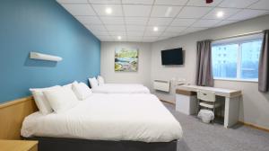 a hotel room with two beds and a desk at Cardiff Bute Terrace Hotel By Belvilla in Cardiff