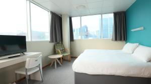 a hotel room with a bed and a desk with a television at Cardiff Bute Terrace Hotel By Belvilla in Cardiff