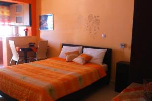 a bedroom with a large bed with an orange blanket at Βlue Horizon Lixouri in Lixouri