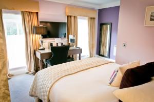 um quarto de hotel com uma cama e uma secretária em Warbrook House Heritage Hotel em Hook