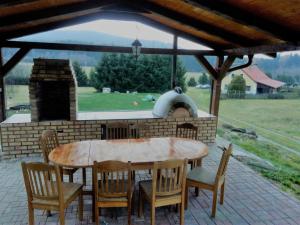 einen Holztisch und Stühle mit einem Backofen im Freien in der Unterkunft Ubytovani Stare Hute, Novohradské hory in Horní Stropnice