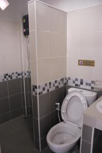 a bathroom with a toilet and a sink at Baan Phu Jad Kan in Uttaradit